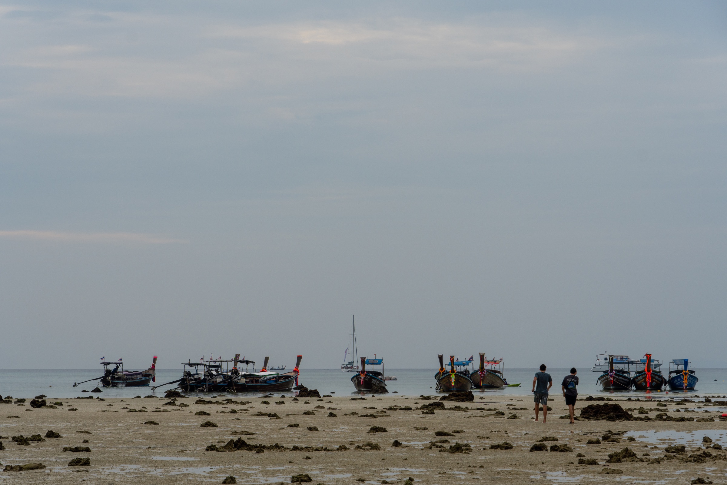Maré baixa em Koh Phi Phi com barcos e pessoas distribuídas ao longe